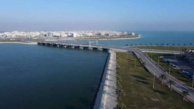 Bridge in Persian Gulf on sunny day, Tarout Island in background. Aerial descending