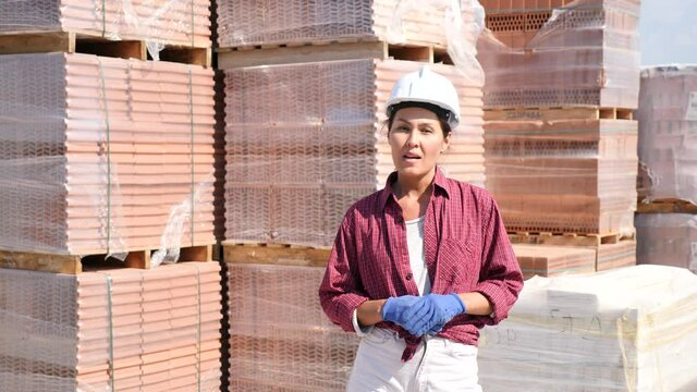 Asian woman worker in helmet beckoning come here gesture at construction store . High quality 4k footage