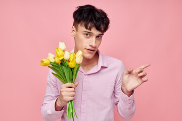 portrait of a young man bouquet of flowers date romance posing pink background unaltered