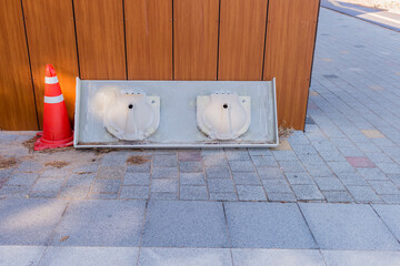 Washroom counter top with two sinks attached leaning against public restroom exterior wall.