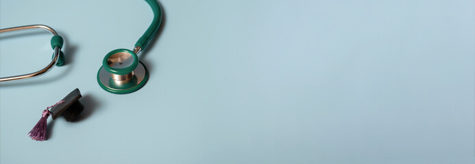 Graduation cap with stethoscope and numbers 2022 on blue background, closeup with copy space....