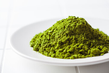 Matcha green tea powder on a white plate.