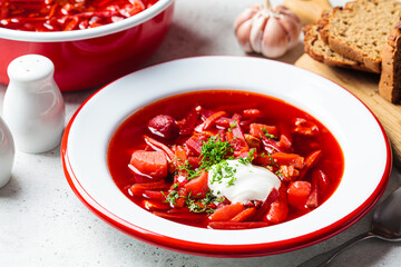 Beetroot soup borsch with garlic, sour cream and dill in plate.