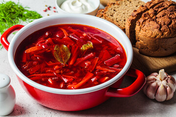 Saucepan of Russian beetroot soup borsch with garlic, sour cream and dill.