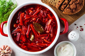 Saucepan of Russian beetroot soup borsch with garlic, sour cream and dill.