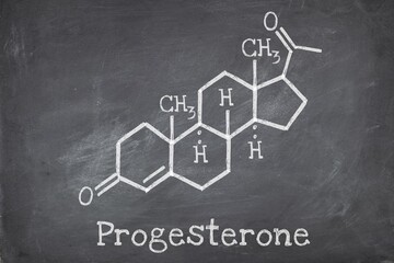 Progesterone female sex hormone molecule on blackboard background.