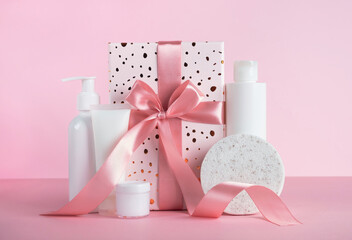 Gift box with cosmetic products on pastel pink background. Body treatment, skincare. Concept of...