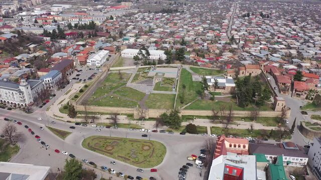 Scenic view from drone of central areas of Telavi city overlooking medieval walled Batonis Tsikhe fortress on spring day, Georgia