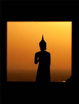 Silhouette Buddha image is located by the window in the temple.