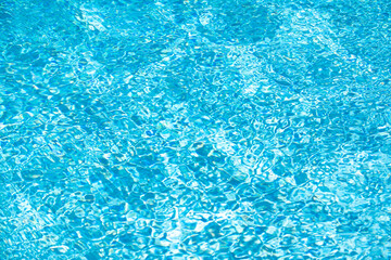 Background of blue water in swimming pool with sun reflection, ripple water wave in pool. Clear water background.