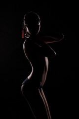 Portrait Swim wear of 20s Asian Woman in shadow low light key with back backlit, side rear view