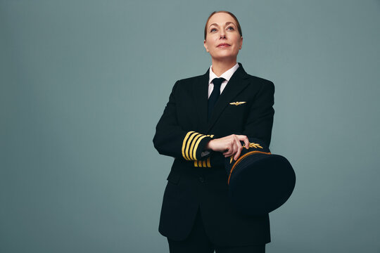 Female airline pilot looking away thoughtfully in a studio