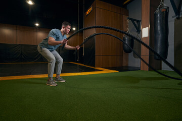 Concentrated serious sporty man doing full-body workout