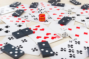 Dominoes, playing cards and dice for board games on table close up.