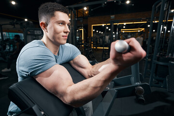 Sportsman training on fitness equipment at gym