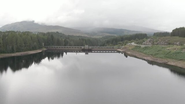 Flying backwards looking at Laggan Dam, located on the River Spean south west of Loch Laggan in the scottish highlands.