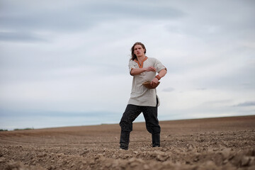 A young peasant sows the field with grain