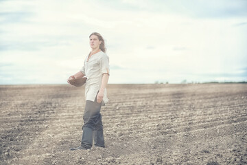A young peasant sows the field with grain