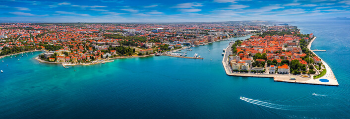 Zadar, Croatia - Aerial panoramic view of the old town of Zadar by the Adriatic sea with motorboat, yacht harbor and blue sky on a bright summer day - obrazy, fototapety, plakaty
