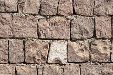 Beautiful texture of an old wall from orange stones with cracks