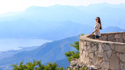 Young tourist woman enjoying view of Kotor bay in Montenegro in mountains. © skumer