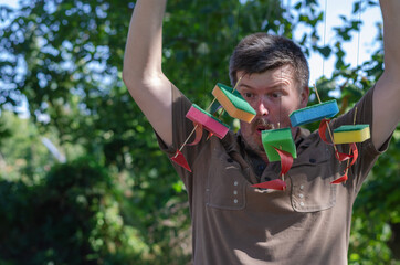 Surprised Adult man holds children's ships tied to a branch. Fiv