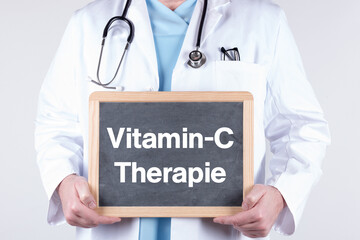 Arzt mit einer Tafel auf der Vitamin-C Therapie steht. Konzept Vitaminmangel.
