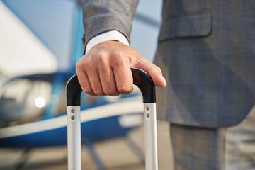 Gentleman with baggage standing near parked helicopter