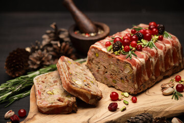 Traditional French terrine covered with bacon on dark wooden background