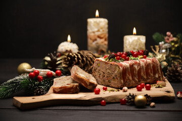 Traditional French terrine covered with bacon and Christmas decoration on dark wooden background