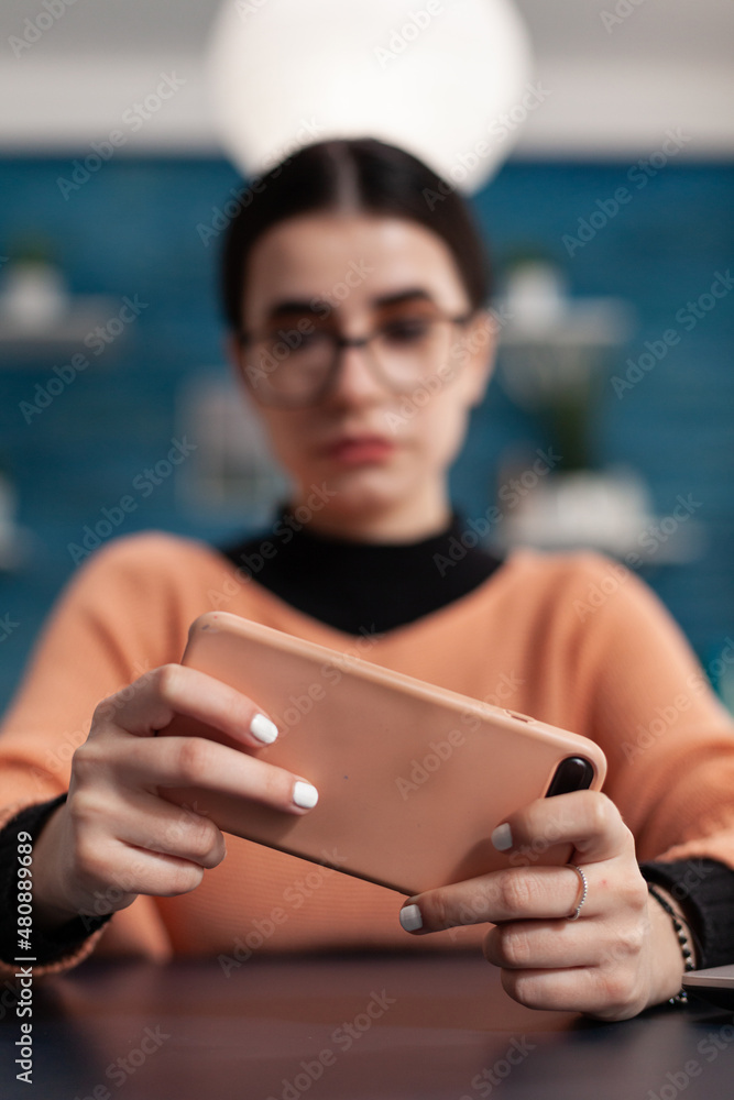 Aufkleber student holding smartphone and looking at the screen. programmer with glasses watching content on mo