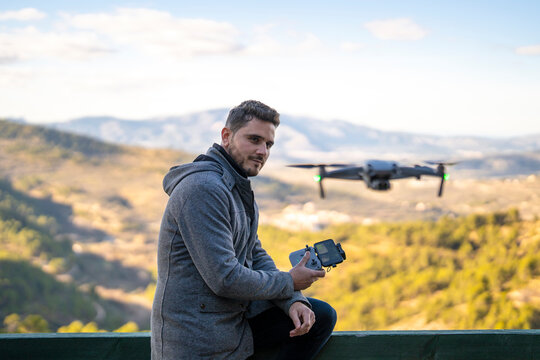 Contemplative pilot with remote control sitting on railing