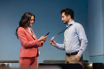 Businesswoman scanning QR code on colleague's identity card at office