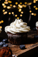 Chocolate cupcakes with blueberries on a dark table