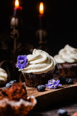 Chocolate cupcakes with blueberries on a dark table