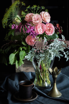 Studio shot of coffee cup and bouquet of Mini Eden roses, annual claries, Queen Annes lace, black-eyed Susans, silver ragwort, mint and dill