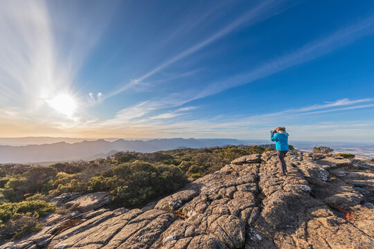 Australia, Victoria, Female tourist taking pictures from Mount William at sunset