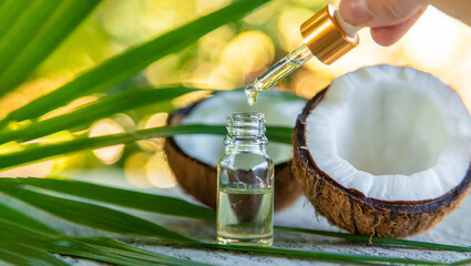coconut oil in a jar on the background of coconut and leaves.