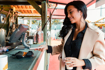 Woman paying through smart phone at food truck in market
