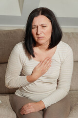   Middle aged mature woman having a heart attack. Woman suffering from chest pain. Health care and...