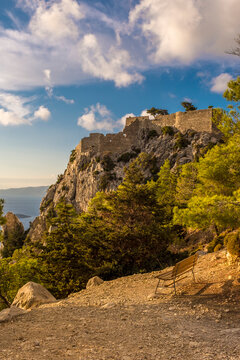 Greece, Rhodes, Rhodes, Empty bench with Castle of Monolithos in background