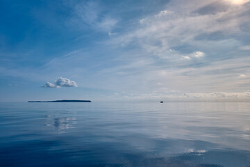 calm sea and white cloud above the island  and water reflection