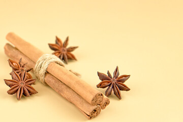 Cinnamon sticks and star anise on a beige background, copy space.