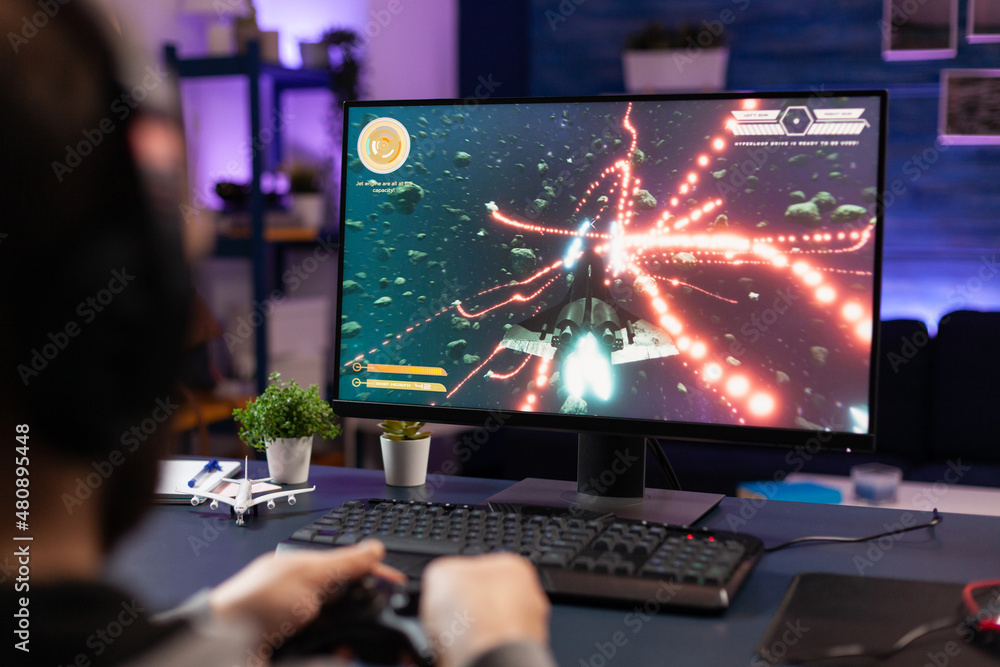 Poster man playing video games with joystick on computer. player using controller and wearing headphones to