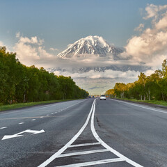 The road against the background of the volcano. Travelling by car. Kamchatka Peninsula, Russia. Travel and tourism in the natural park