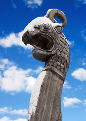 wooden dragon head on Drakkar on winter blue sky