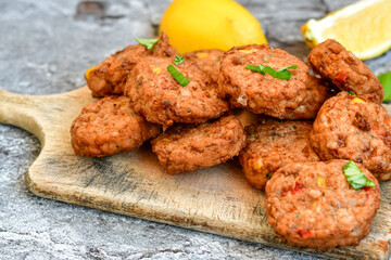 Home made  pork meatballs with  fresh cherry tomatoes on wooden rustic background. Deep fried minced  meat patties on cutting board.