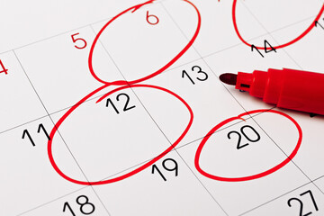 Calendar page with red pen close up and many red circle for design in your ideas and work concept