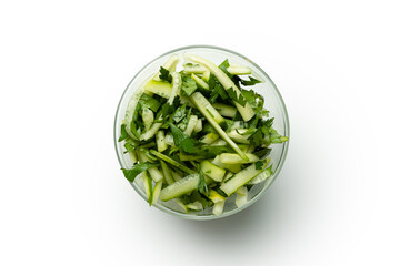 sliced cucumber with parsley in a transparent plate on a white background