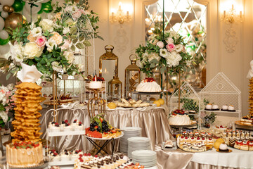  Candy bar. Wedding sweet table with cake and various desserts decorated with flowers. Buffet with delicious pastries. Delicious wedding buffet with cupcakes. Organization weddings.